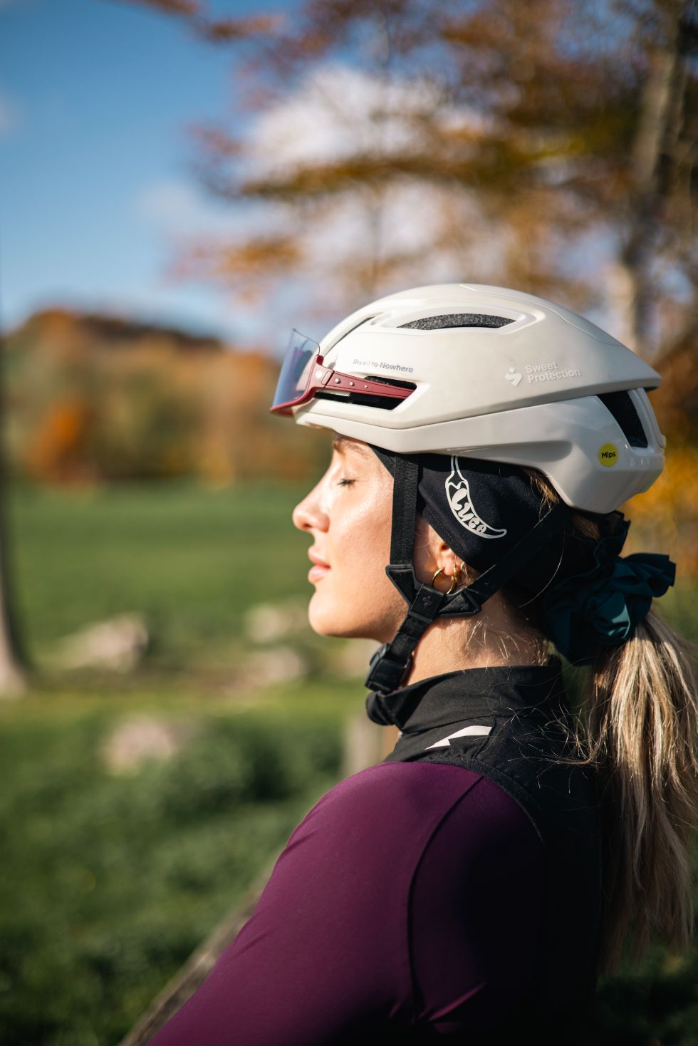 Woman-wearing-a-white-Sweet- Protection-cycling-helmet-and-black-Luca-headband-outdoors