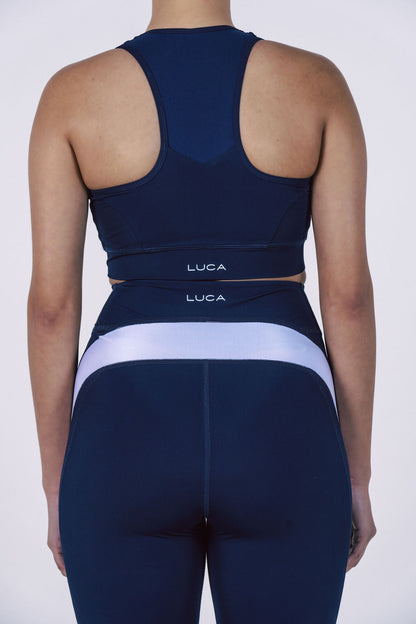 Back-view-of-woman-wearing-a- navy-blue-LUCA-activewear-set- featuring-a-racerback-cycling-bra- and-high-waisted-leggings-with-a- wide-supportive-white-contrast-band-across-the-lower-back-Athletic fitness-gear