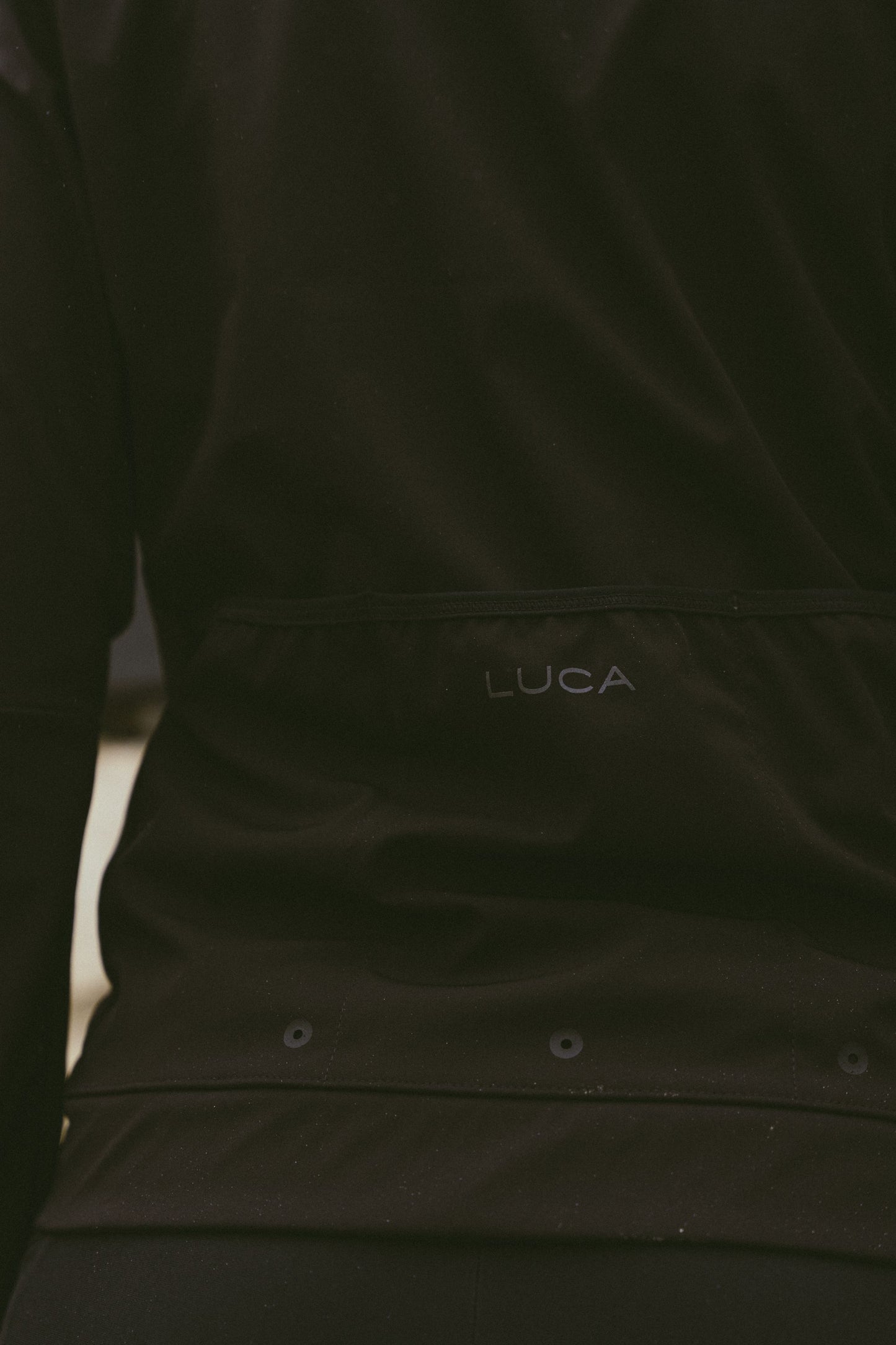Back-detail-of-the-Luca-Momentum-Jacket-in-black-featuring-the-discrete-logo-and-horizontal-rear-pocket-design
