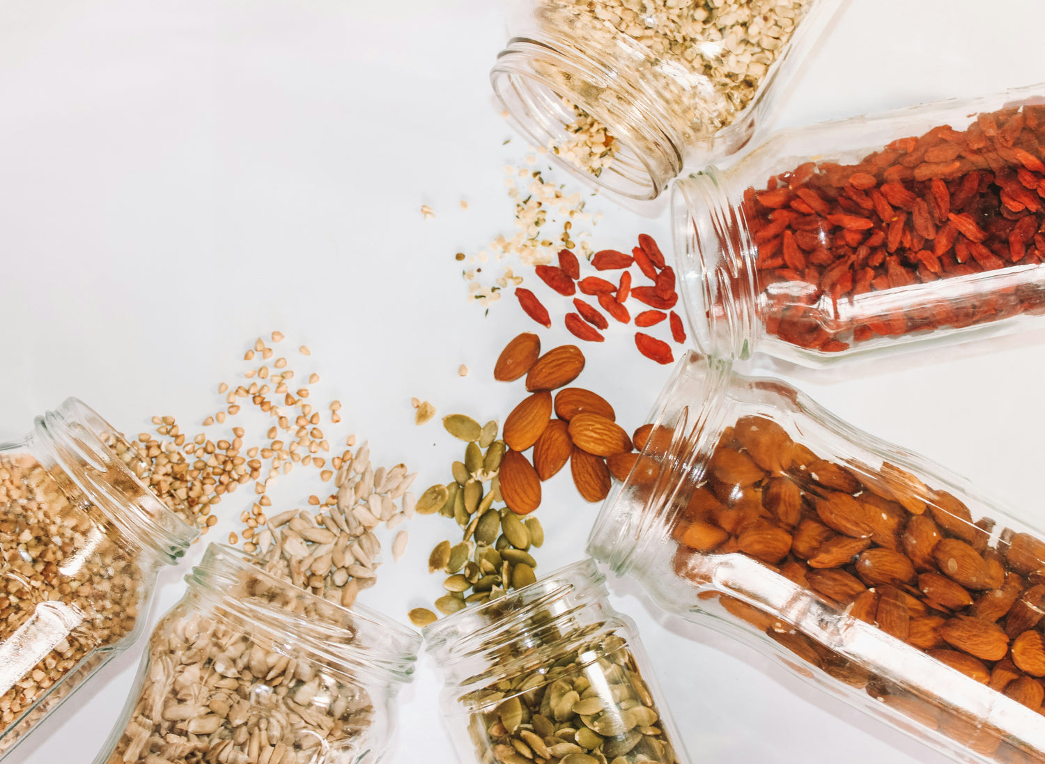 Bulk-organic-ingredients-almonds-goji-berries-pumpkin-seeds- sunflower-seeds-and-rolled-oats-in- glass-storage-jars