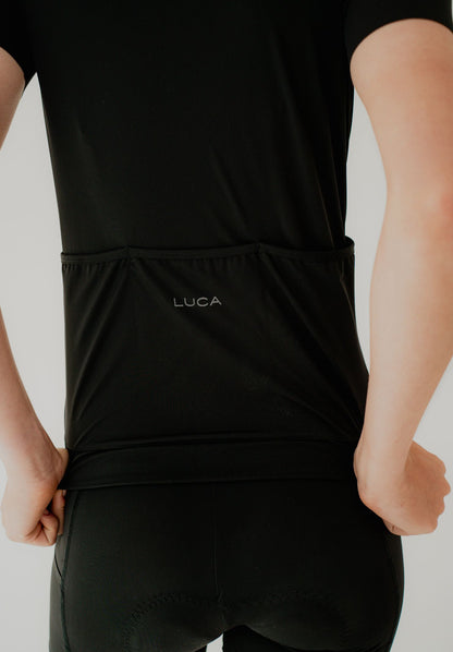 Person-wearing--Solstice Jersey - Black-clothing-with-LUCA-printed-on-the-waistband