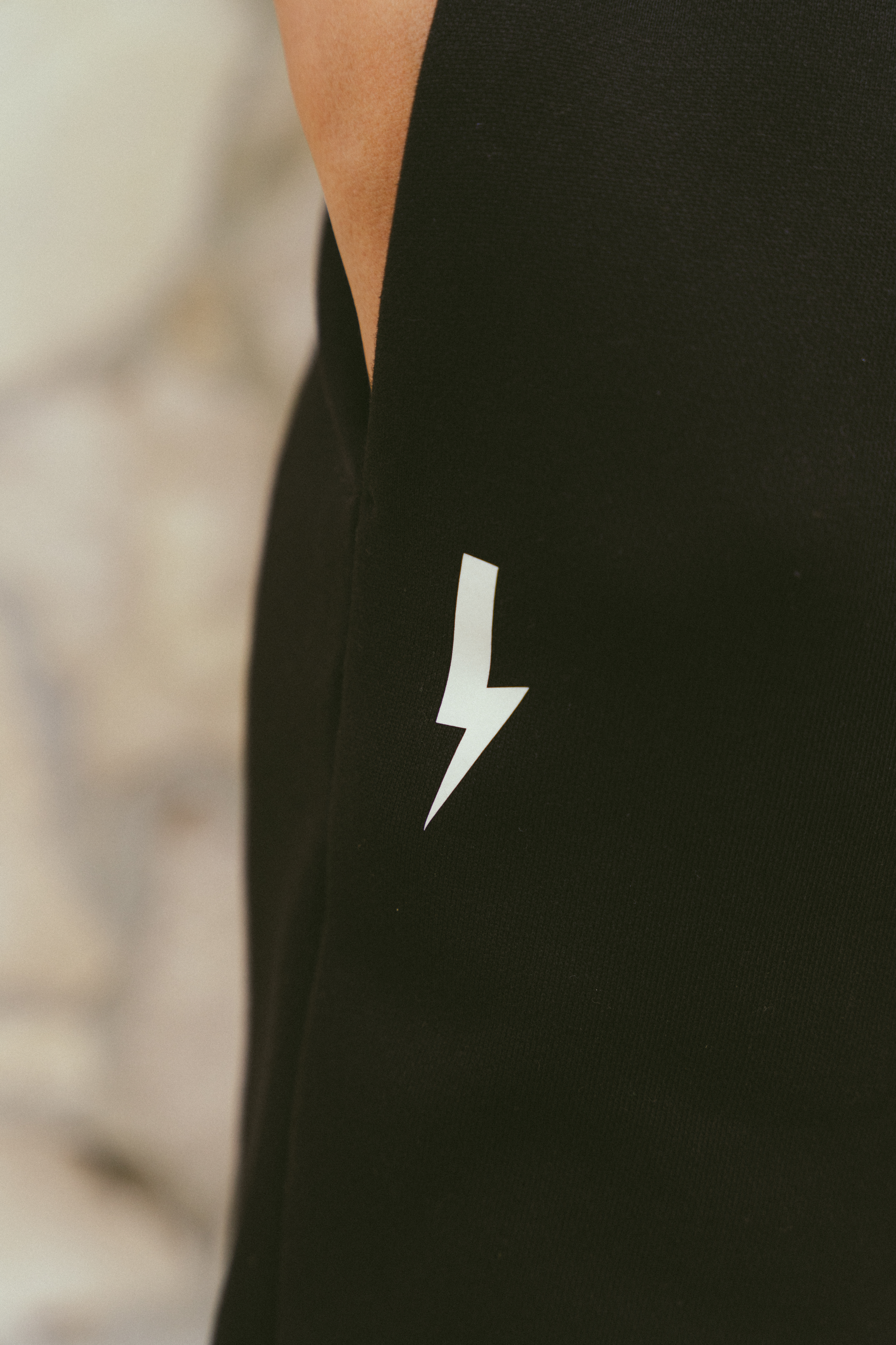 Close-up-of-a-black-garment-with-a-white-lighting-bolt-sign-on-the-side-The-background-is-blured