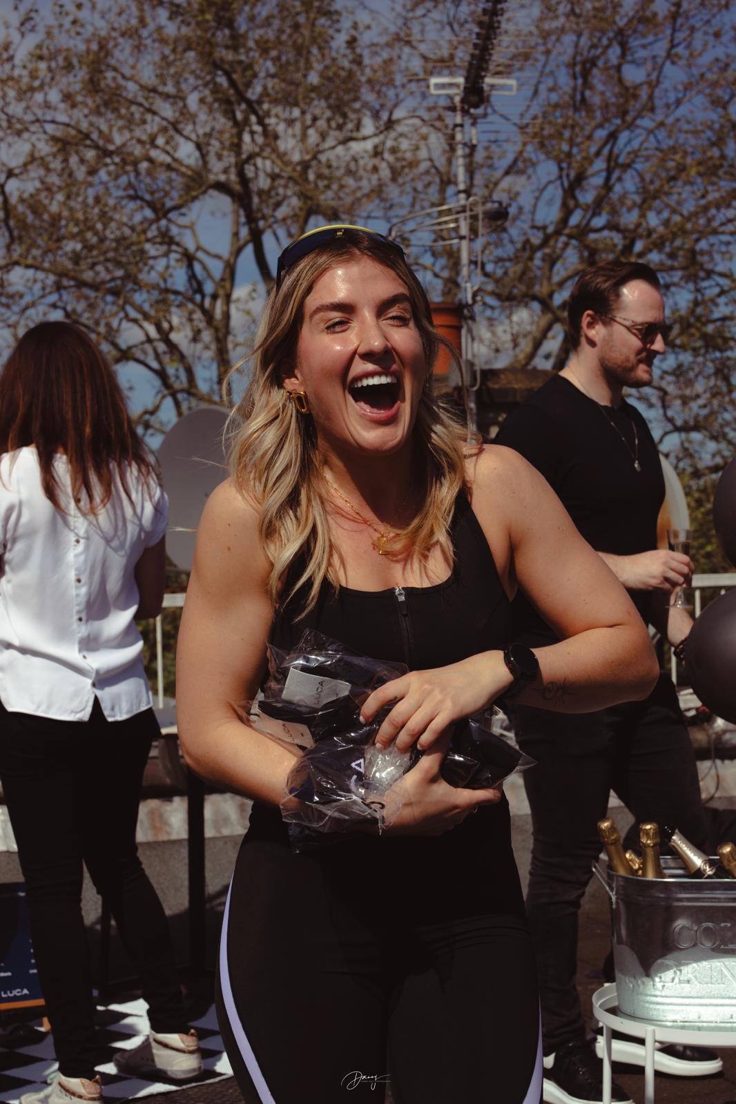 Excited-woman-in-black-athletic- wear-holding-merchandise-product bags-outdoors