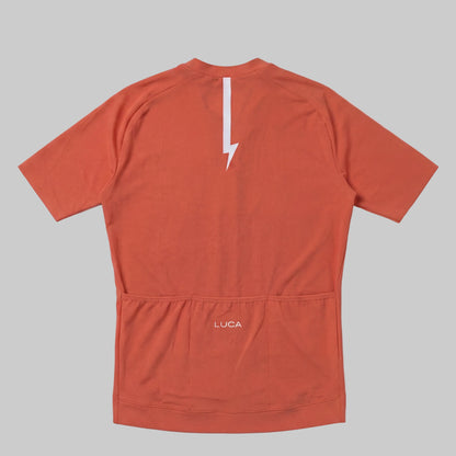LUCA Soleil women's cycling jersey in aperol - back view with reflective bolt and pocket detail