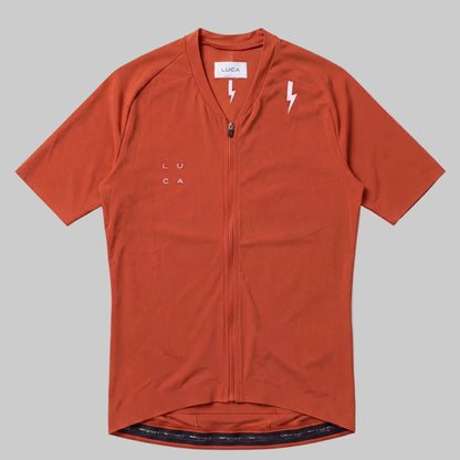 LUCA Soleil women's cycling jersey in aperol - front flat lay with V-neckline and bolt detail