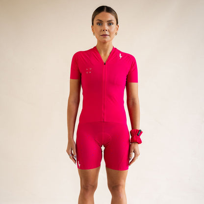 Cyclist wearing LUCA Soleil jersey and matching cycling shorts in hibiscus, front view