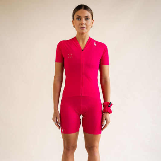 Cyclist wearing LUCA Soleil jersey and matching cycling shorts in hibiscus, front view