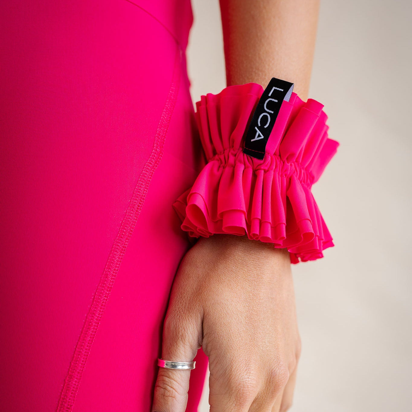 LUCA Uplift scrunchie in hibiscus worn on wrist next to matching jersey