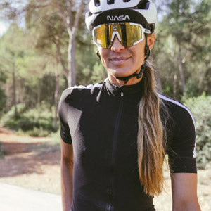 Close-up product-shot-of-a-woman- in-a black-cycling-jersey,-white- helmet-and-NASA-branded- performance-sunglasses