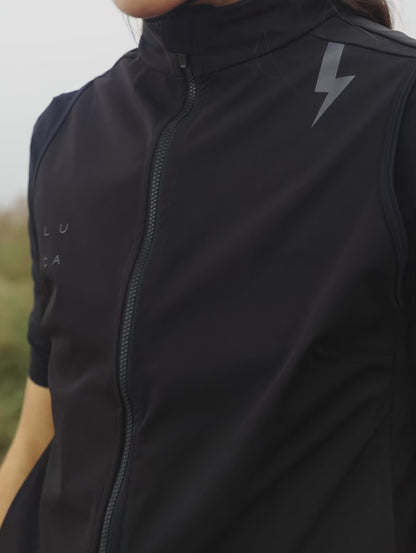 Short-video-clip-showing-a-model-wearing-the-Luca-black-cycling-vest-fully-zipped-The-west-features-a-lighting-bolt-graphic-on-the-shoulder-and-a-full-length-zipper-A-white-stripe-on-the-arm-of-the-underlying-short-sleeve-jersey-is-revealed
