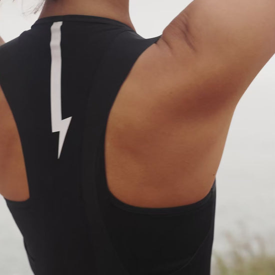Short-video-demonstrating-the-fit-of-a-black-sleeveless-athletic-one-piece-  with-cycling-short-legs-a-square- neckline-and-a-contrasting-white- lightning-bolt-sign-on-the-upper-back