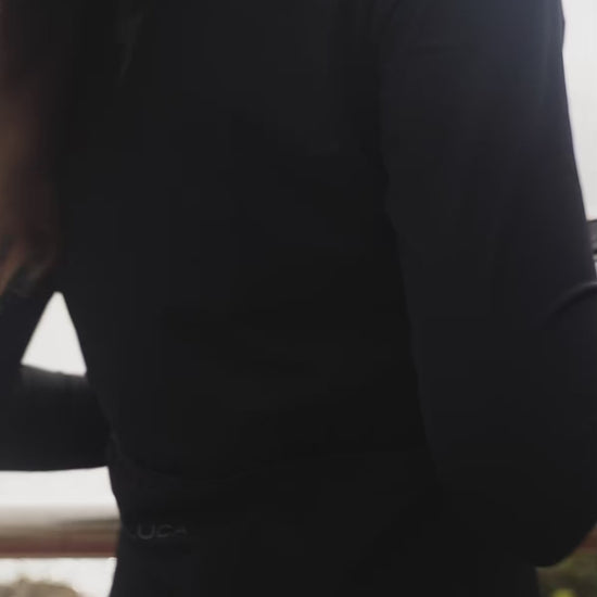 A-short-promotional-video-featuring-a-model-wearing-the-black-long-sleeve-athletic-jersey-the-model-zips-the-jesey-up-highlighting-the-high-collar-quality-fabric-and-reflective-logo-on-the-shoulder-and-chest