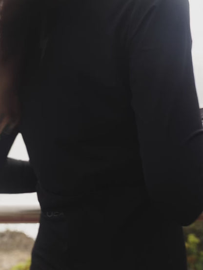 A-short-promotional-video-featuring-a-model-wearing-the-black-long-sleeve-athletic-jersey-the-model-zips-the-jesey-up-highlighting-the-high-collar-quality-fabric-and-reflective-logo-on-the-shoulder-and-chest