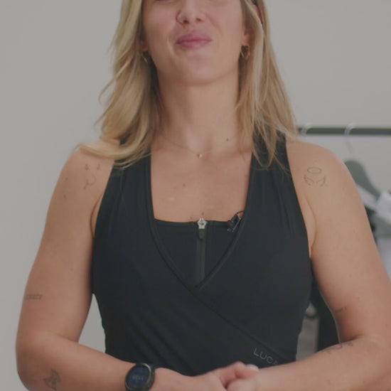Video-promoting-a-versatile-black- athletic-jumpsuit-The-video-features-a-woman-explaining-that-this-new- version-is-designed-for-both- cycling- class-and-casual-wear-noting-that-the-bum-padding-and-reflective-white- stripes-were-removed-and-the-back- now-features-a-white-lightning-bolt- logo-for-a-sport- look