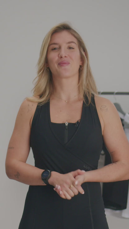 Video-promoting-a-versatile-black- athletic-jumpsuit-The-video-features-a-woman-explaining-that-this-new- version-is-designed-for-both- cycling- class-and-casual-wear-noting-that-the-bum-padding-and-reflective-white- stripes-were-removed-and-the-back- now-features-a-white-lightning-bolt- logo-for-a-sport- look