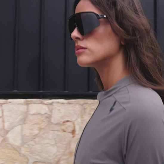 Video-of-a-female-model-posing-in-a-grey-LUCA-long-sleeve-cycling-jersey-and-shield-sunglssess-highlighting-the-garment-fit-and-full-front-zipper